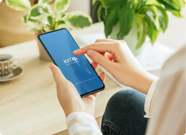 A guy holding phone with kayan app