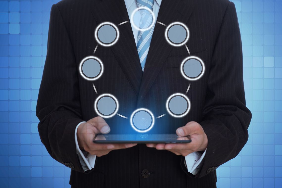 A businessman holds a tablet with glowing circular icons above, symbolizing digital tools and innovation in talent acquisition.